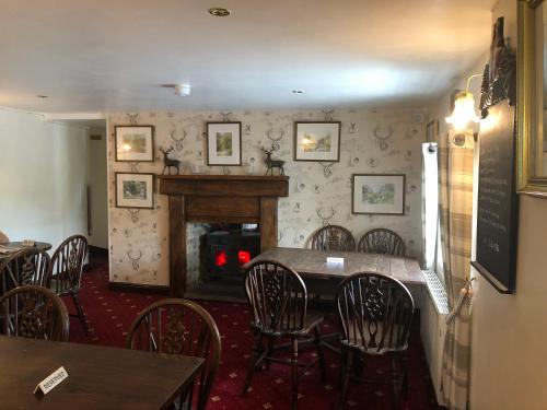 a dining room with a table and chairs and a fireplace at The Jug & Glass Inn in Hartington