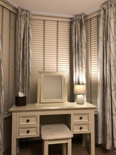 a desk with a tv on it in a room with curtains at Number 46 in Hastings