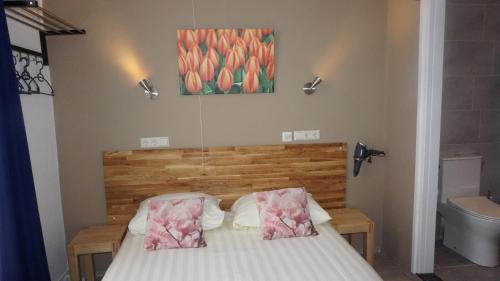 a bedroom with a bed and a painting on the wall at Hotel De Wilde Kriek in Valkenburg