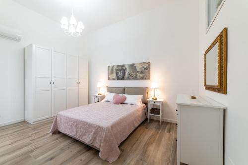 una camera bianca con un letto e due lampade di Casa Donna Gina - Puglia Mia Apartments a Monopoli