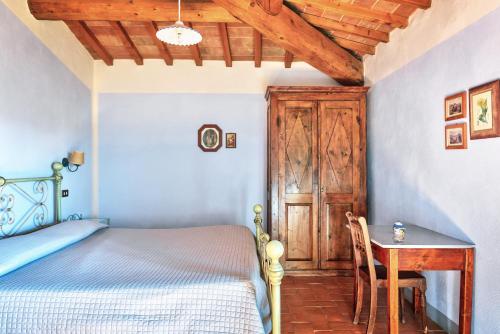 a bedroom with a bed and a desk and a table at Hotel Borgo Casabianca in Serre di Rapolano