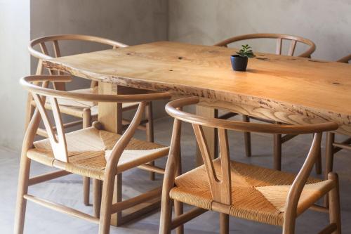 a wooden table with two chairs and a wooden table with a plant on it at CASA DA ILHA - Slow Living Residence & Suites in Ponta Delgada