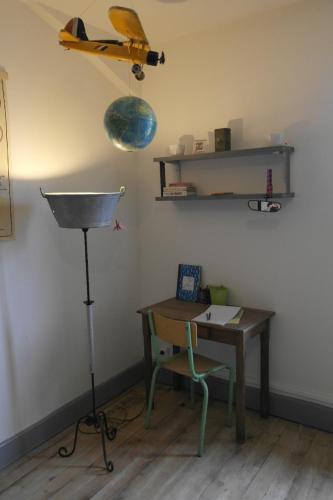 Cette chambre comprend un bureau et une table avec un plan mural. dans l'établissement Gîte, Vintage Touch, à Hannonville-sous-les-Côtes