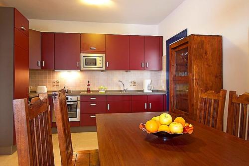 a kitchen with a wooden table with a bowl of fruit at Villa Tamia & Atlántico Marina Rubicón in Playa Blanca