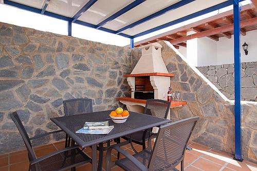 a patio with a table and chairs and a pizza oven at Villa Tamia & Atlántico Marina Rubicón in Playa Blanca