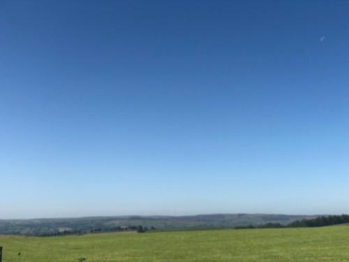 a green field with a blue sky in the background at The Jug & Glass Inn in Hartington