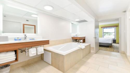 een grote badkamer met een bad en een wastafel bij Holiday Inn Express Hotel & Suites Pigeon Forge, an IHG Hotel in Pigeon Forge