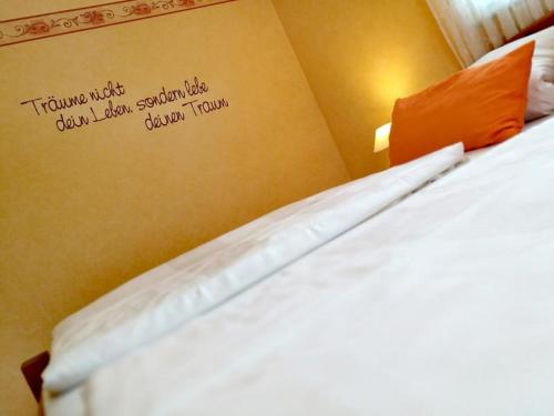 Un dormitorio con una cama con un cartel en la pared. en Ferienwohnung A Casa Mia, en Gengenbach