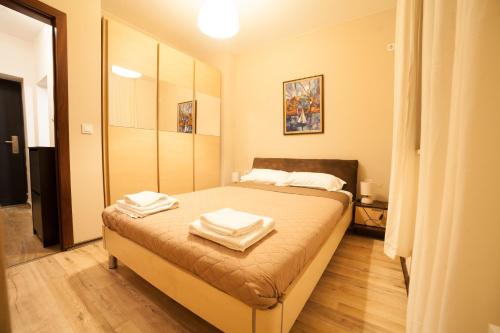 a bedroom with a bed with two towels on it at Апартамент МИТИ in Pleven