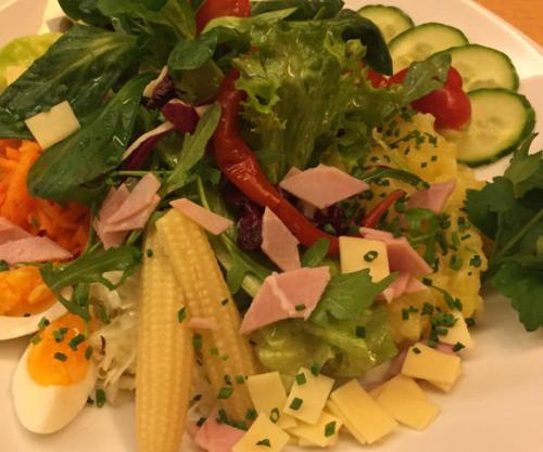 a plate with a salad with cheese and vegetables at Zenntaler Hof in Neuhof an der Zenn