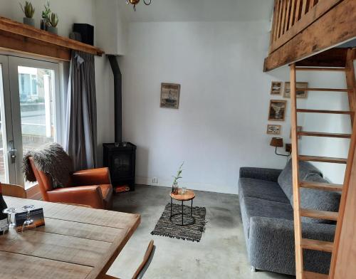 a living room with a couch and a bunk bed at Beach Cottage free parking in Noordwijk aan Zee