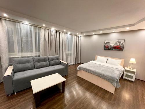 a living room with a bed and a couch at Apartment on Krasnoarmeyskaya in Kemerovo