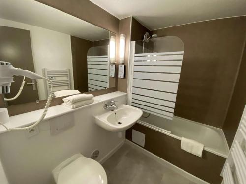 W łazience znajduje się umywalka, toaleta i lustro. w obiekcie Kyriad Fontenay - Trésigny w mieście Fontenay-Trésigny