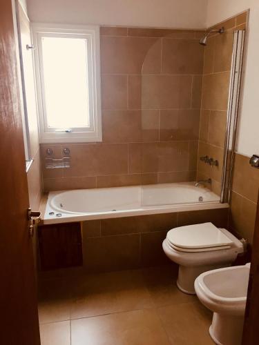 a bathroom with a tub and a toilet and a sink at Cabaña Sol - FINCA PUDUAM in Villa General Belgrano