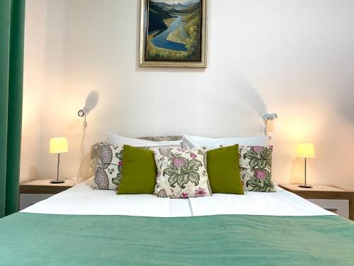 a bedroom with a bed with green and white pillows at Villa Forever in Belgrade