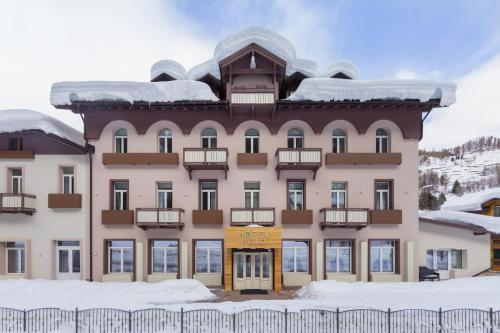 a large building with snow on the ground at Hotel Pejo in Peio Fonti