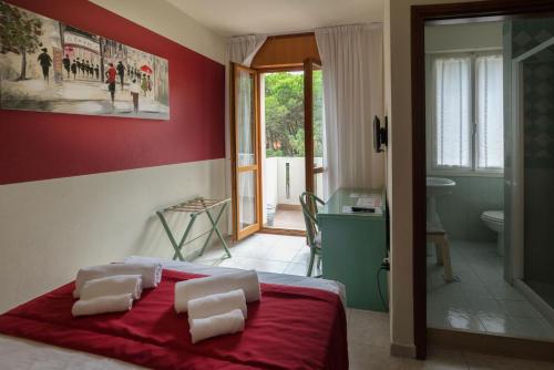 a bedroom with a bed and a bathroom at Hotel Airone in Bibione