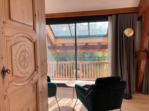 une chambre avec deux chaises et une grande fenêtre dans l'établissement Domaine Jacqueline Père & Filles, à Aix-les-Bains