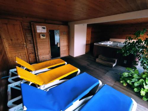 a room with blue and yellow chairs and a stove at A l'Orée du Bois in Dommartin-lès-Remiremont