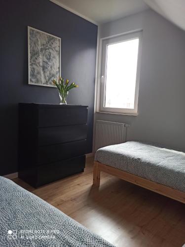 a bedroom with two beds and a window at Domek Całoroczny Pod Dworem in Wola Kalinowska