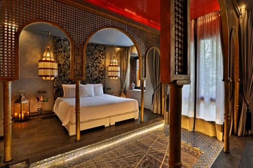 ein Schlafzimmer mit einem Bett in einem Zimmer mit einem Torbogen in der Unterkunft Dar Kandi in Marrakesch