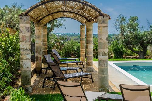 eine Terrasse mit Stühlen und einem Pool in der Unterkunft Villa Torre Dell'alto mare blocco n2 in Alliste