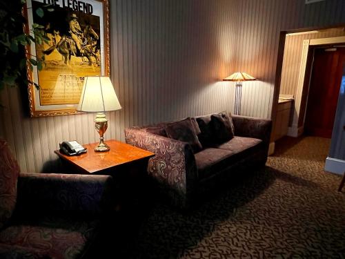 a living room with a couch and a table with a lamp at Celebrity Boutique Hotel in Deadwood