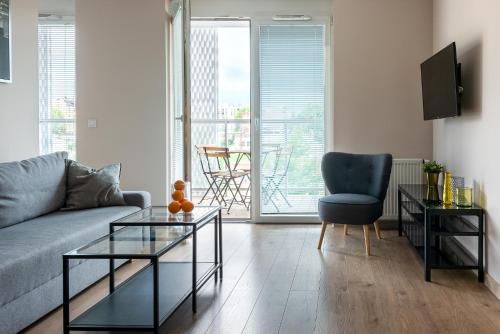 a living room with a couch and a chair at apartamenty-wroc Atal Towers in Wrocław