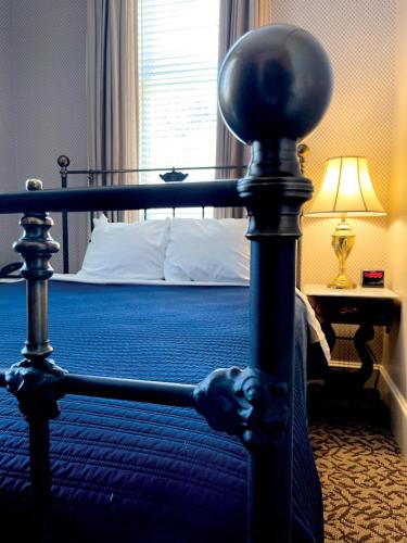 a bedroom with a bed with a blue bedspread at Celebrity Boutique Hotel in Deadwood