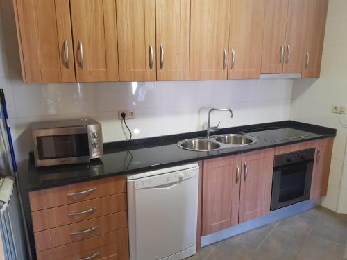 a small kitchen with a sink and a microwave at Apartamentos Farrai llova 