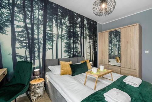 a bedroom with a bed and trees mural at Premium Apartments Poznań Airport by Renters in Poznań