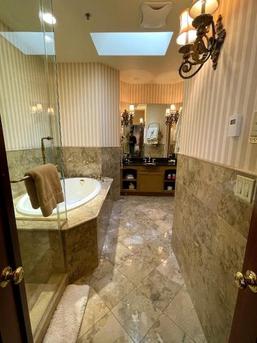 a large bathroom with a tub and a sink at Celebrity Boutique Hotel in Deadwood