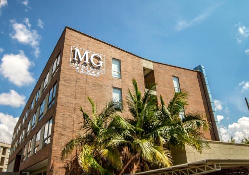 a msg building with a palm tree in front of it at MG Hotels & Suites in Rionegro
