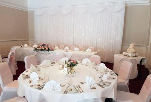a room with two tables with white tablecloths at Holiday Inn Ashford Central by IHG in Ashford
