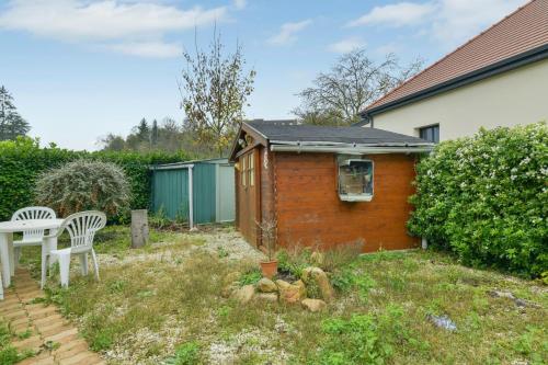 a small house with a table and chairs in the yard at Maison charmante à Villenauxe in Villenauxe-la-Grande
