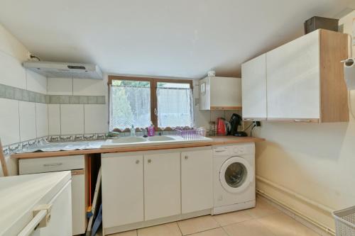a kitchen with a sink and a washing machine at Maison charmante à Villenauxe in Villenauxe-la-Grande