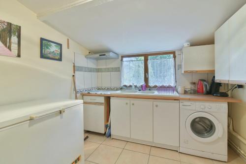 a kitchen with a sink and a washing machine at Maison charmante à Villenauxe in Villenauxe-la-Grande