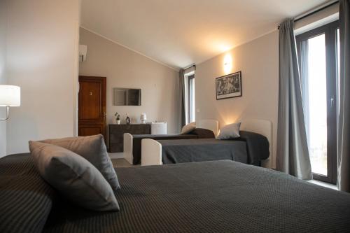 a bedroom with two beds and a living room at Un passo dal mare - Guest House in Lido Di Fondi