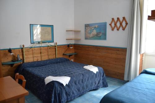 a bedroom with two beds and a table and a table at Piccolo Tirreno Hotel Residence in Procida
