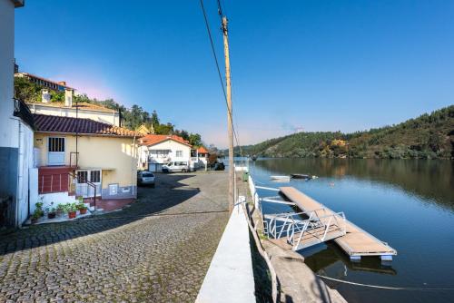 a river with boats parked next to a building at Villa Douro in Santa Maria Da Feira