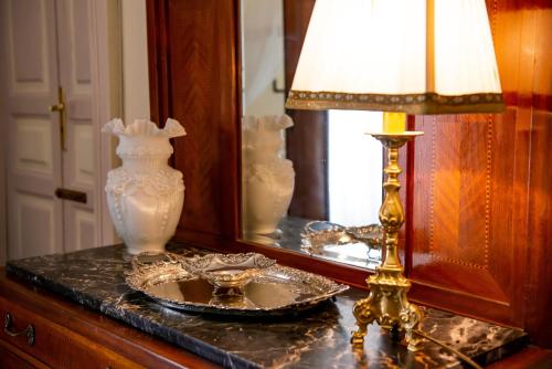 a table with a mirror and a lamp and a plate at Casa Isabella B&B in Rocca San Giovanni