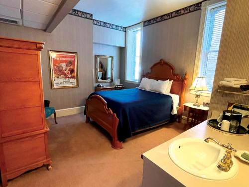 a bedroom with a bed and a sink in it at Celebrity Boutique Hotel in Deadwood