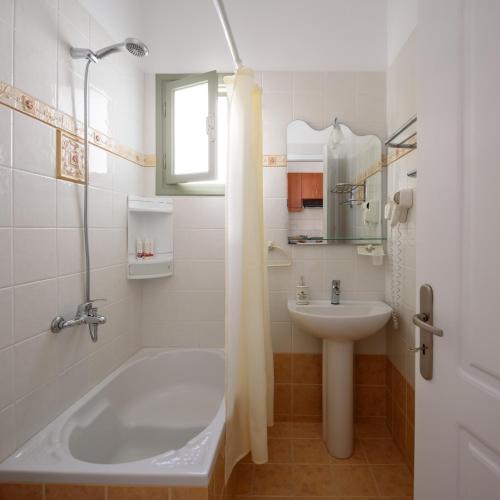 a bathroom with a tub and a sink and a shower at Mirabeli Apartments & Suites in Pollonia