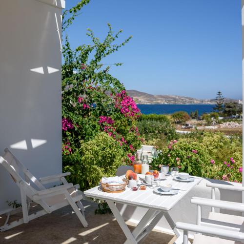 a white table and chairs on a patio with flowers at Mirabeli Apartments & Suites in Pollonia