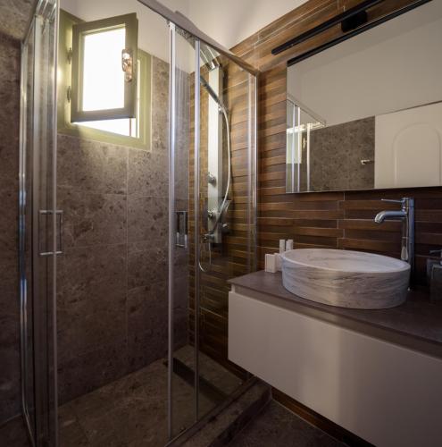 a bathroom with a sink and a shower at Mirabeli Apartments & Suites in Pollonia