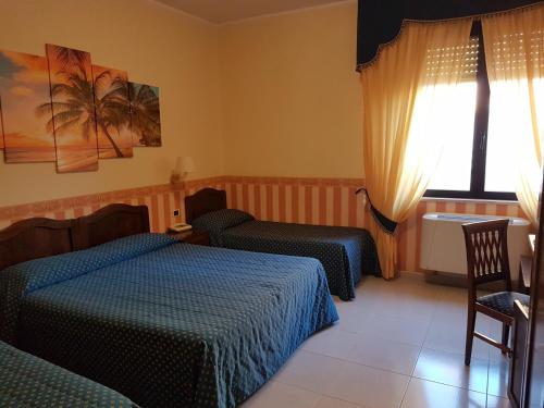 a hotel room with two beds and a window at Hotel Eden Sul Lago in Bolsena