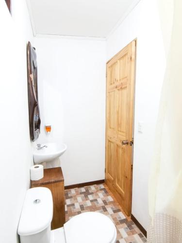 a bathroom with a toilet and a sink at Casita happy feet and tours corcovado in Drake
