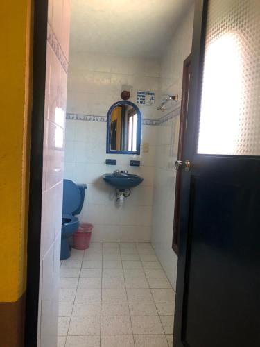 a bathroom with a blue toilet and a sink at San Pablo in Pátzcuaro