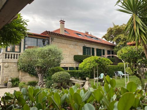 a house with a garden in front of it at Hotel Playa Samil Vigo in Vigo
