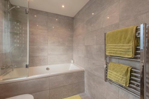 a bathroom with a tub and a toilet and a shower at Sandpiper Cottages in Newquay